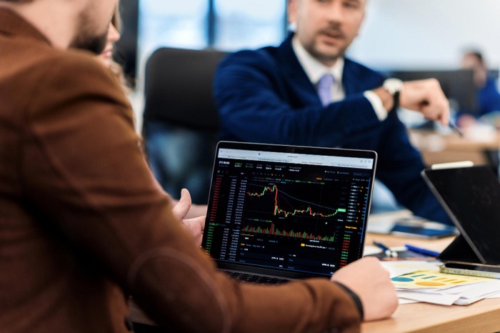 Businessman in a meeting watching trading chart on his laptop